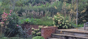 brick retaining wall yorkstone steps country garden grasses roses autumn garden